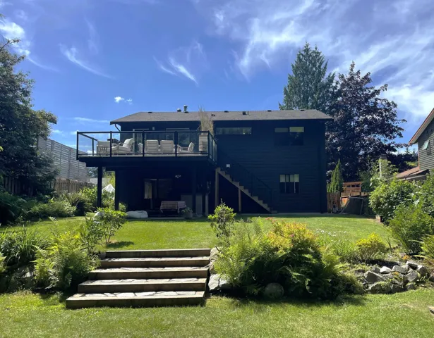 Back of house with stairs and a deck