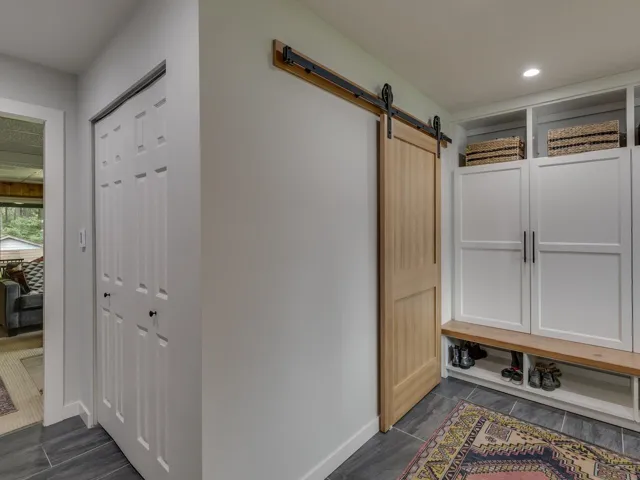 Mudroom featuring a barn door and recessed lighting