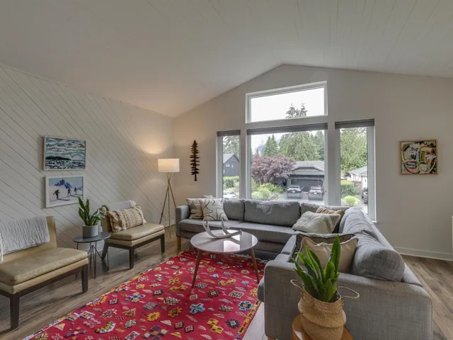 Living room featuring wood finished floors, high vaulted ceiling, and wooden walls