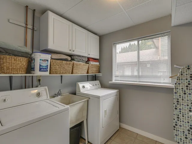Washroom featuring separate washer and dryer, cabinet space, and light tile patterned floors