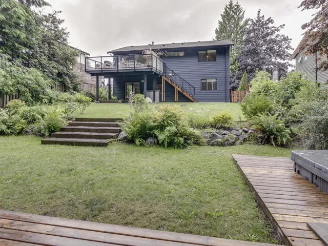 Back of house with stairs and a wooden deck