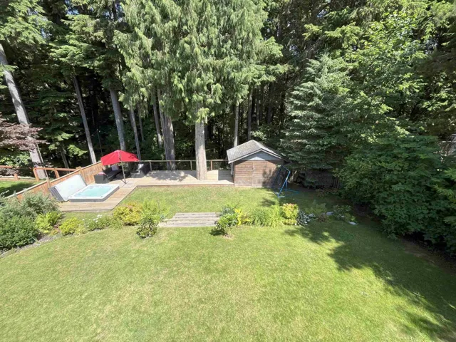 View of yard featuring a deck and a storage shed