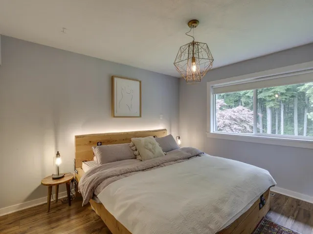 Bedroom featuring a chandelier and dark wood-type flooring