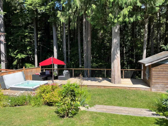 View of grassy yard featuring a wooden deck and outdoor lounge area