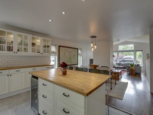 Kitchen with wood counters, wine cooler, tasteful backsplash, a breakfast bar area, and vaulted ceiling