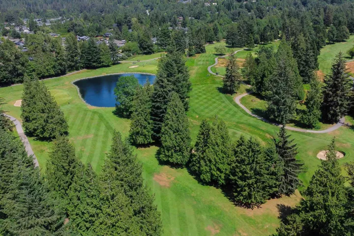 Drone / aerial view of a nearby body of water and a golf course