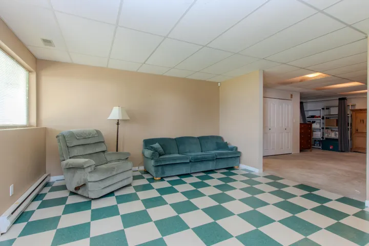 Sitting room with a baseboard heating unit and a paneled ceiling