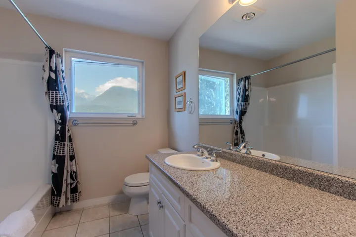 Full bath featuring light tile patterned flooring, vanity, and shower / tub combo