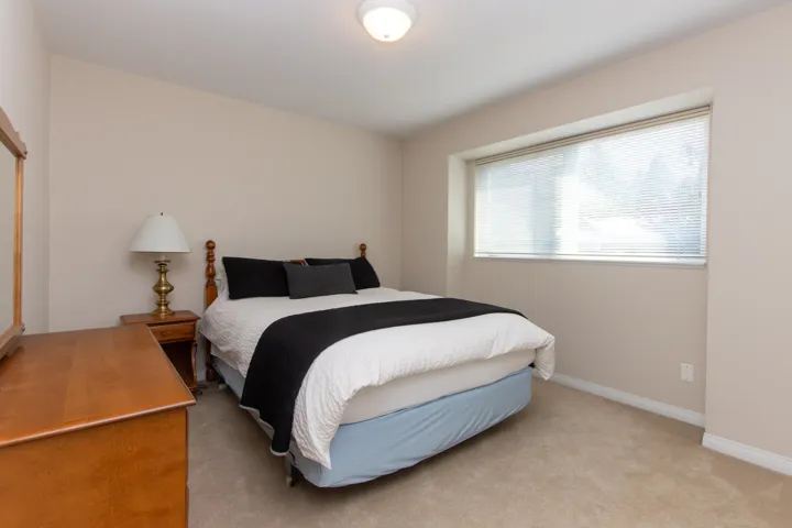 Bedroom with light colored carpet and baseboards