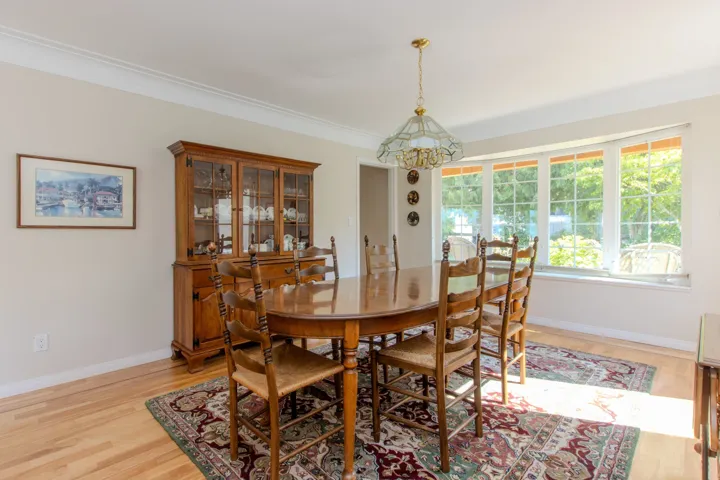 Dining room with light wood-type flooring, a chandelier, and ornamental molding