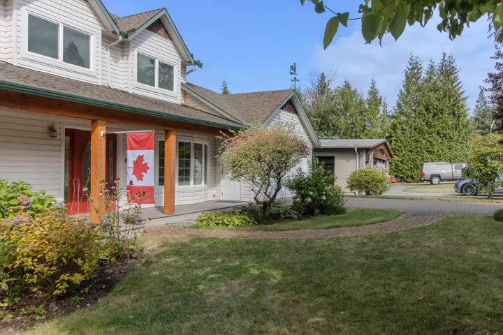 View of front of property with a porch, a front yard, and roof with shingles