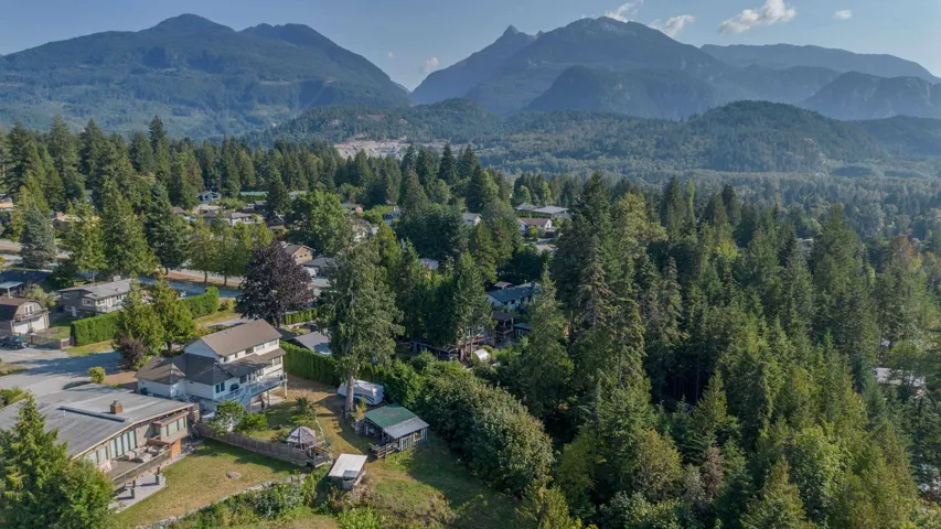 Aerial view of property and surrounding area featuring a mountain backdrop