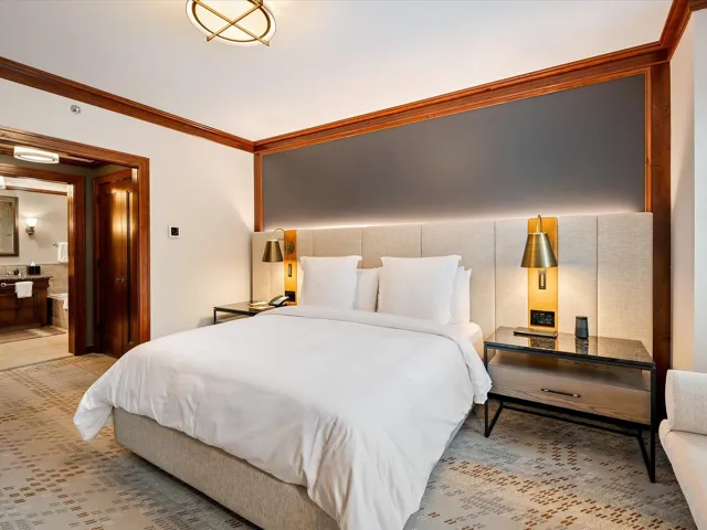 Bedroom with ornamental molding and connected bathroom
