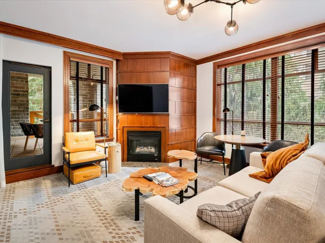 Living room with ornamental molding, baseboards, and a glass covered fireplace