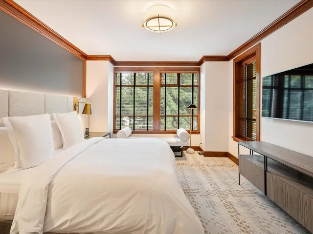 Bedroom with crown molding, light colored carpet, and baseboards