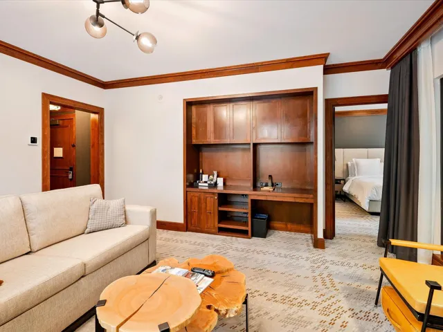 Living room featuring crown molding, baseboards, and light carpet