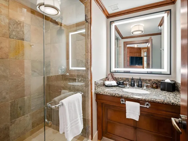 Full bathroom with a shower stall, crown molding, vanity, and visible vents