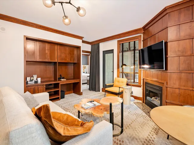 Living area featuring a glass covered fireplace, baseboards, and ornamental molding