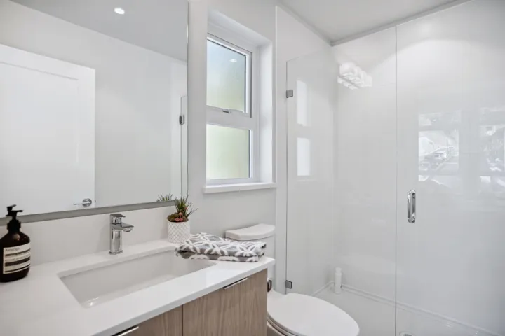 Bathroom with a shower stall, toilet, and vanity