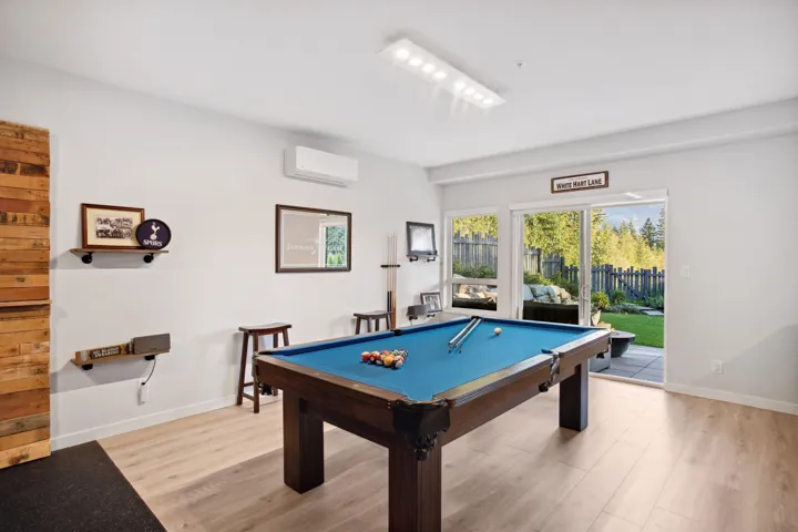 Game room with a wall mounted air conditioner, light wood-style flooring, pool table, and baseboards
