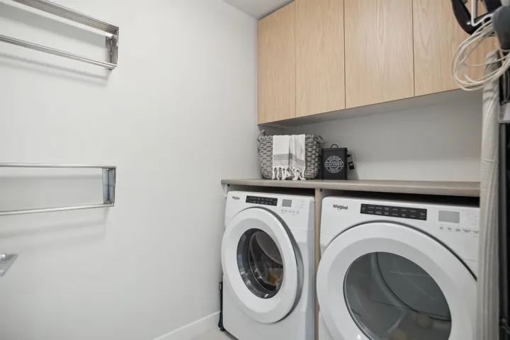 Washroom featuring separate washer and dryer and cabinet space