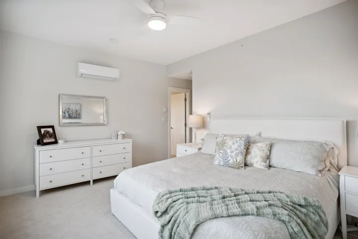 Bedroom featuring a wall mounted AC, carpet, and ceiling fan