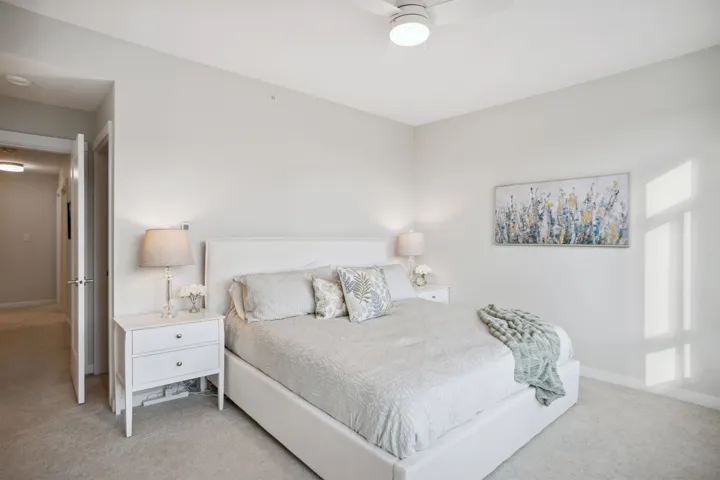 Bedroom featuring light carpet, baseboards, and a ceiling fan