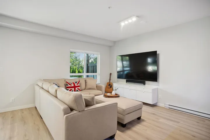Living area featuring light wood-type flooring, a baseboard heating unit, and baseboards