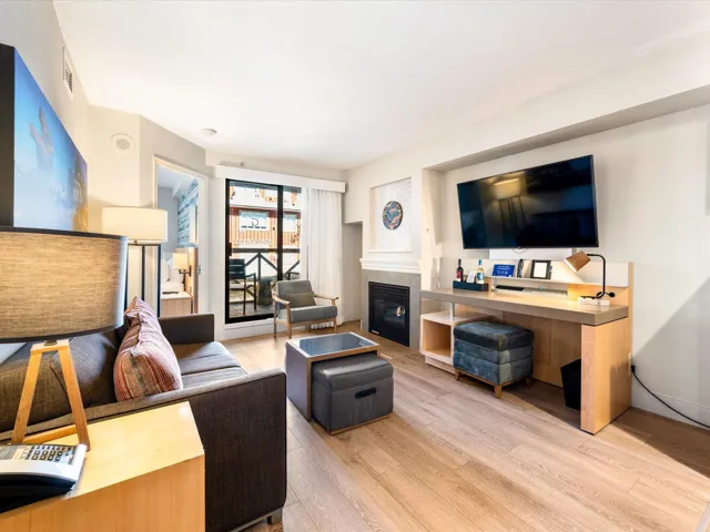Living area with light wood-style floors and a tiled fireplace