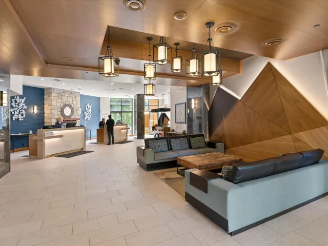 Building lobby with expansive windows, wooden walls, and recessed lighting