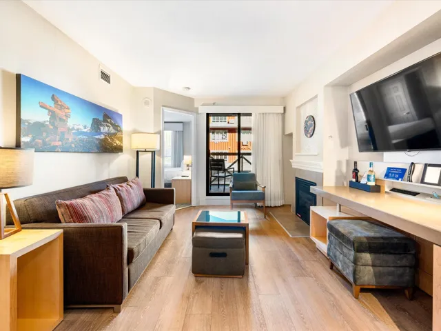 Living room with a tiled fireplace and light wood finished floors