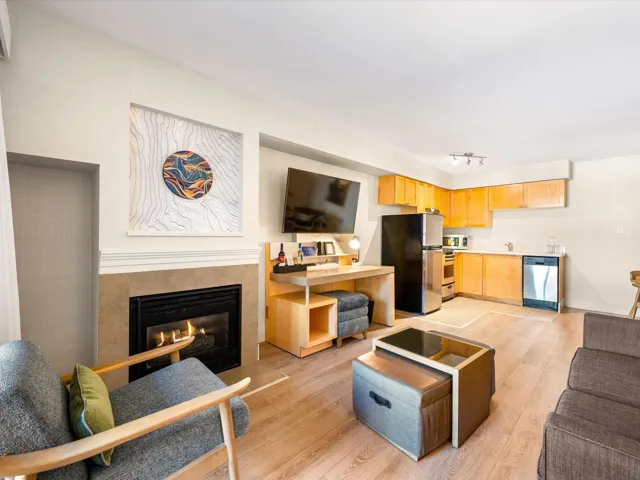 Living room featuring light wood-style floors and a glass covered fireplace