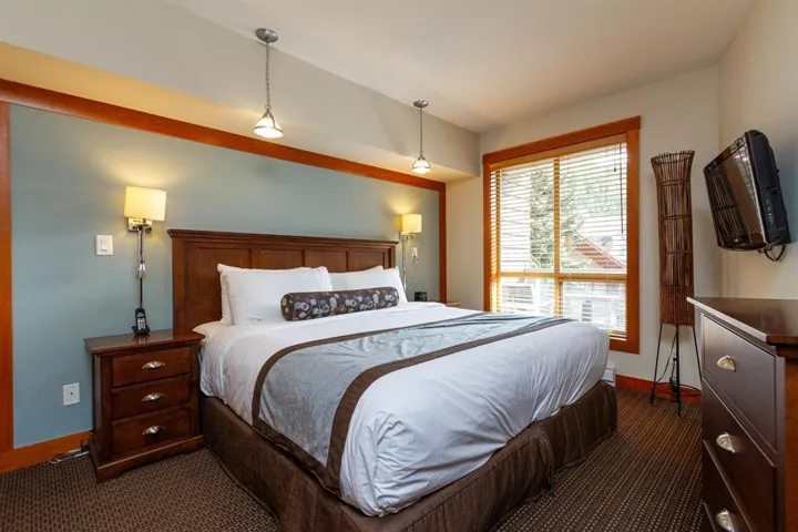 Bedroom with dark carpet and baseboards