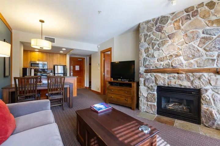 Carpeted living area featuring a fireplace and baseboards
