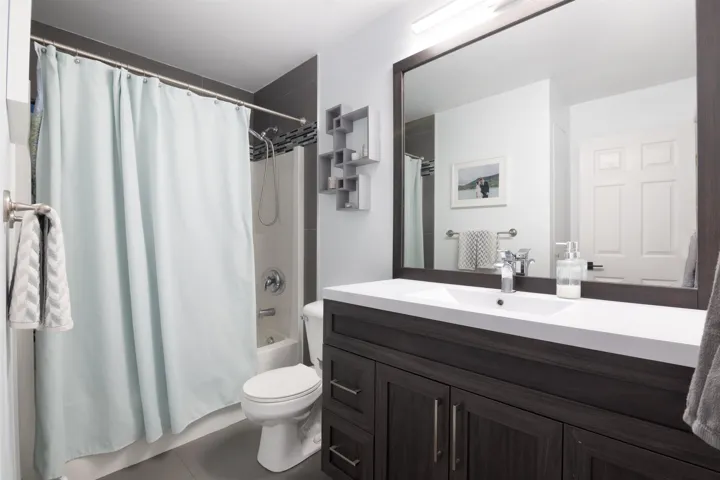 Full bath with tile patterned flooring, vanity, toilet, and shower / bath combo with shower curtain