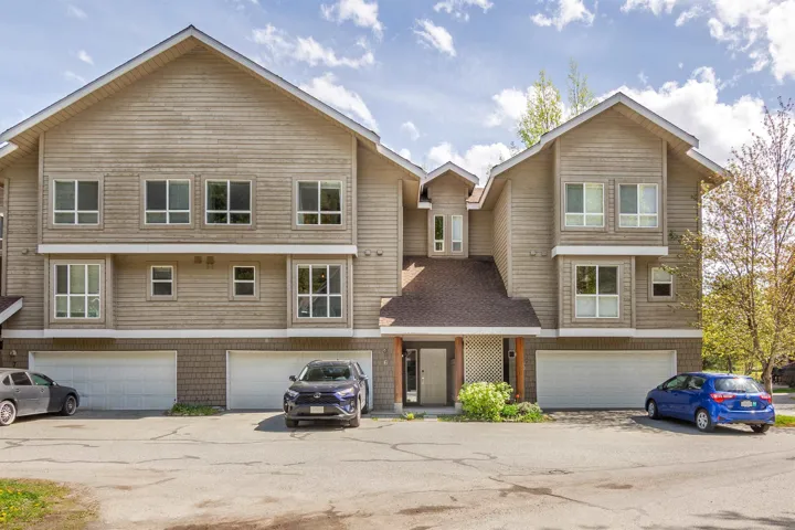 Townhome / multi-family property featuring an attached garage and a shingled roof