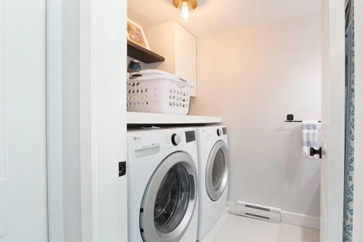 Washroom with tile patterned flooring, laundry area, separate washer and dryer, baseboards, and baseboard heating