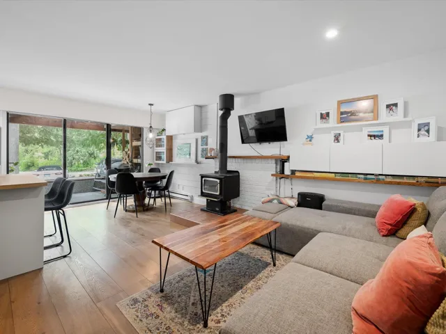 Living room with a wood stove, hardwood / wood-style floors, and recessed lighting