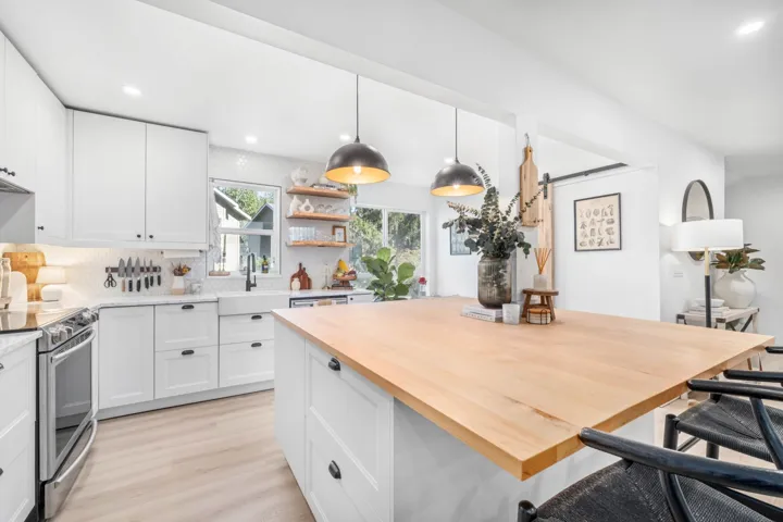 Kitchen featuring recessed lighting, a barn door, pendant lighting, stainless steel electric range oven, and open shelves