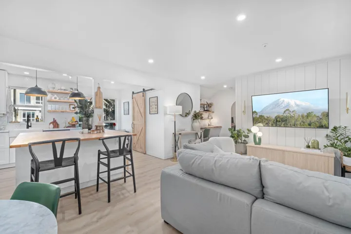 Living room featuring a barn door, recessed lighting, and light wood-style flooring
