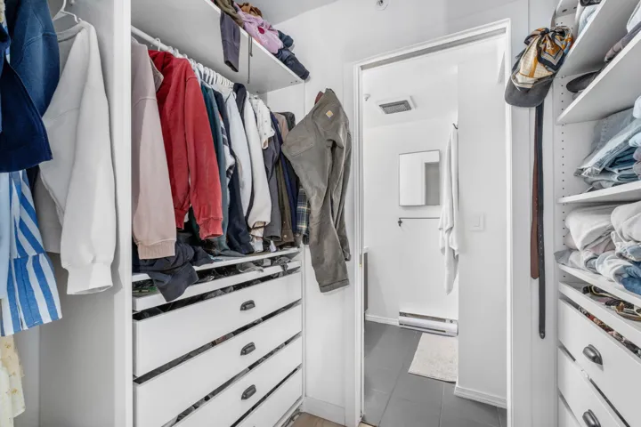 Walk in closet featuring tile patterned flooring and a baseboard heating unit