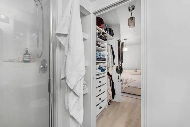 Walk in closet with light wood-style floors