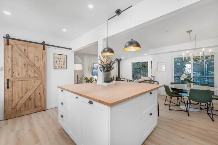 Kitchen with white cabinetry, butcher block counters, pendant lighting, recessed lighting, and a center island