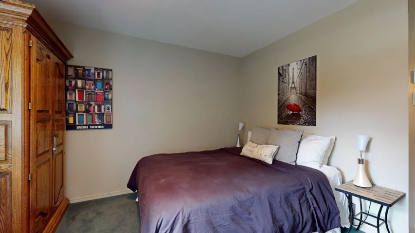Bedroom featuring carpet and baseboards