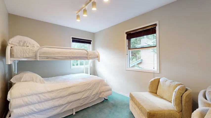 Bedroom with carpet flooring, multiple windows, and track lighting