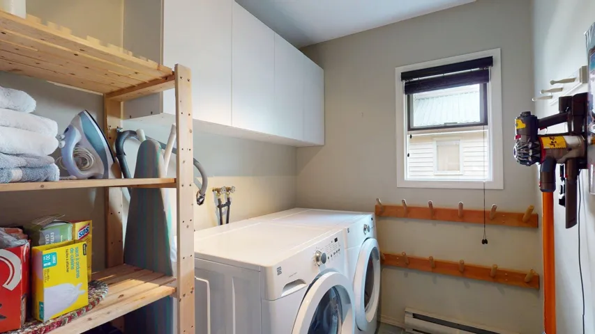 Washroom featuring cabinet space, independent washer and dryer, and baseboard heating