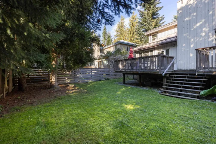 Fenced backyard featuring a wooden deck and stairway