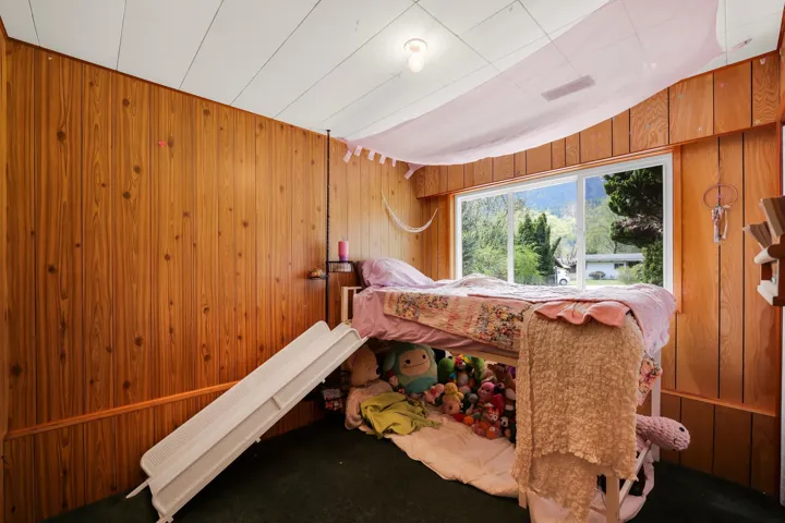 Carpeted bedroom with wood walls
