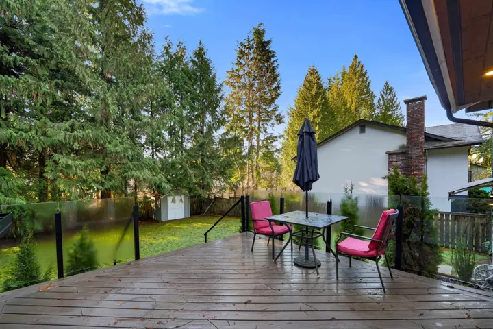 Deck featuring outdoor dining space, a shed, and a fenced backyard
