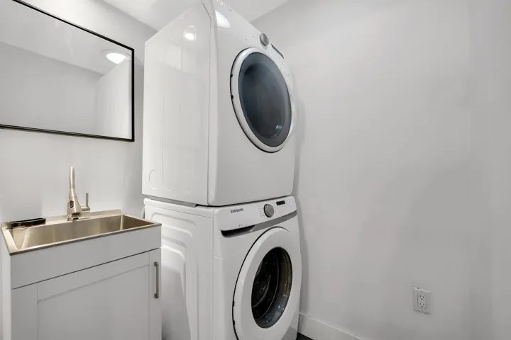 Laundry area with stacked washer / drying machine and cabinet space